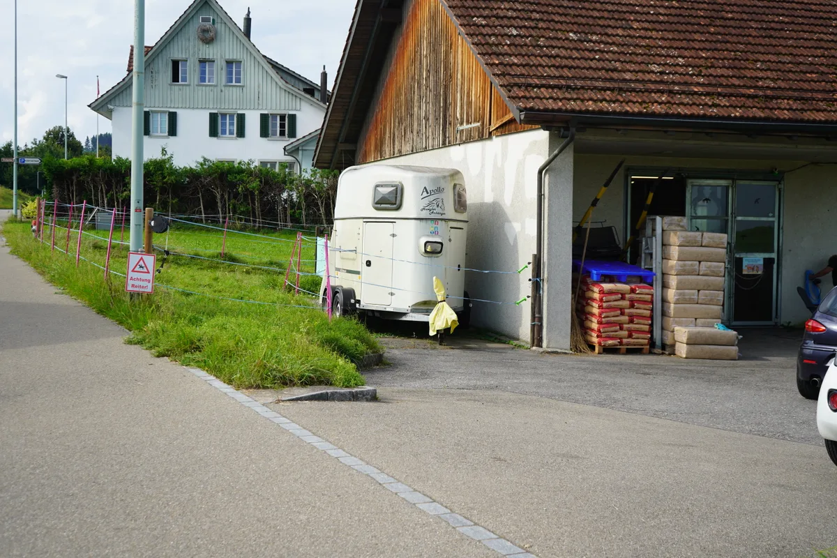 Man sieht die Zufahrt zum Hof von der Hauptstrasse aus.